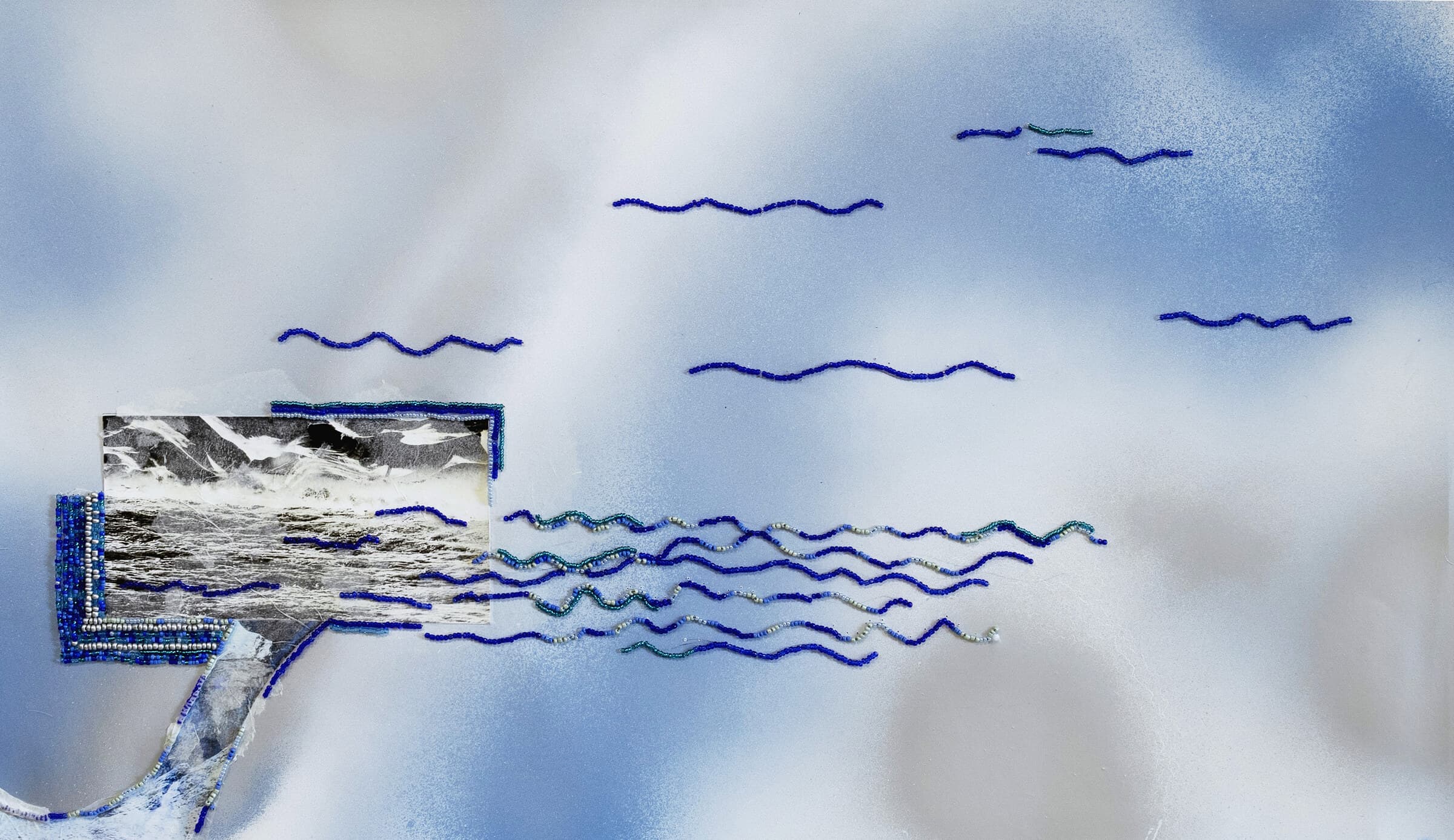 Líneas de abalorios azules que salen de una fotografía del mar pegada al papel
